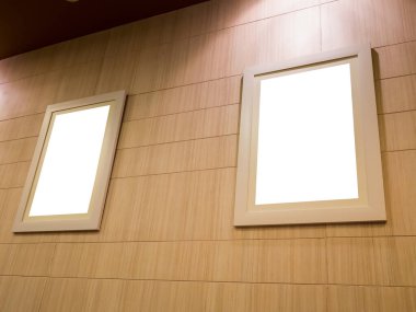 Işık ve ahşap duvarlı boş fotoğraf çerçevesi