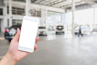 Bulanık arabaların arka planında cep telefonu kullanan bir kadın.