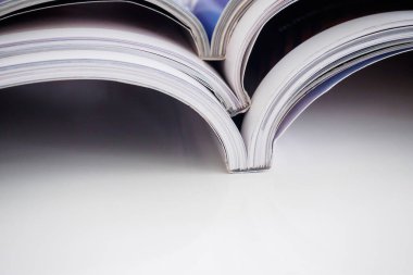 Oturma odasındaki beyaz masaya yığılmış dergiler yığını, kapatın.