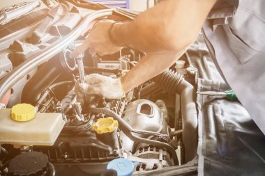 Araba servis merkezinde ingiliz anahtarı çalışan ve araba tamir eden bir tamirci.