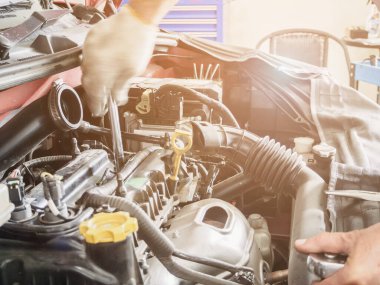 Araba servis merkezinde ingiliz anahtarı çalışan ve araba tamir eden bir tamirci.