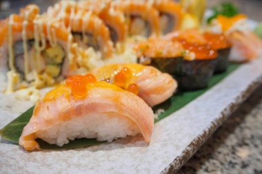 Somon suşili sashimi ve suşi dürümleri yakın planda.