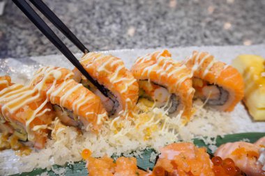 Somon suşili sashimi ve suşi dürümleri yakın planda.