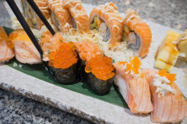 Somon suşili sashimi ve suşi dürümleri yakın planda.