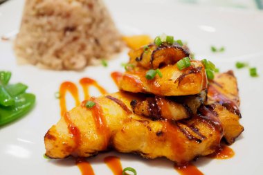 Baharatlı soslu ızgara tavuk bifteği ve pilav.