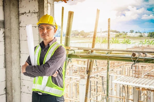在建筑工地手握防护头盔和蓝图纸的亚洲商人 建筑工程师 — 图库照片