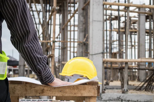 Genç iş adamı profesyonel mühendis bina inşaatında proje üzerinde çalışıyor.