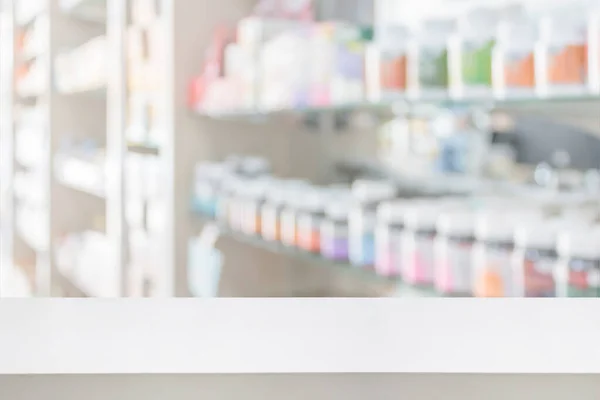 pharmacy store counter table top with blur medicine on shelves in the drugstore background