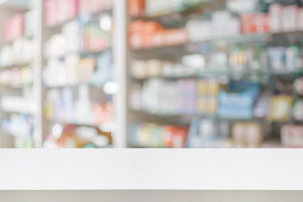 pharmacy store counter table top with blur medicine on shelves in the drugstore background