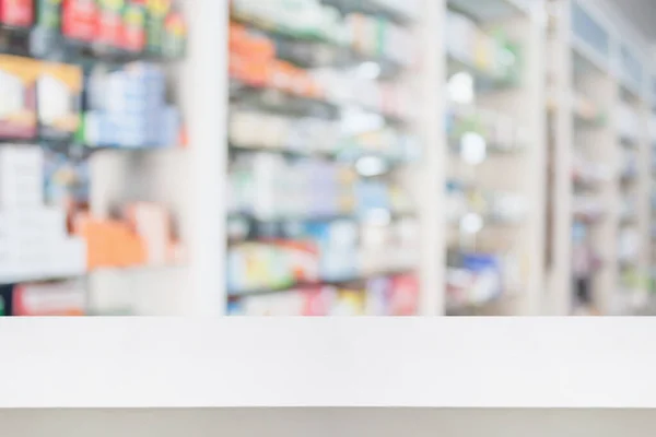 pharmacy store counter table top with blur medicine on shelves in the drugstore background