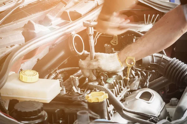 Araba servis merkezinde ingiliz anahtarı çalışan ve araba tamir eden bir tamirci.