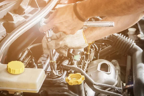 Araba servis merkezinde ingiliz anahtarı çalışan ve araba tamir eden bir tamirci.