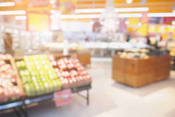 Supermarket with fresh fruits and vegetable on shelves in store blurred grocery background