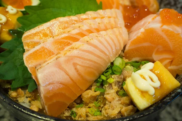 fresh salmon with egg on top of japanese rice in bowl, salmon ikura don