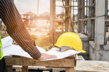 Genç iş adamı profesyonel mühendis bina inşaatında proje üzerinde çalışıyor.