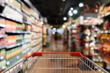 Süpermarket koridoru bulanık arka planı olan alışveriş arabası.