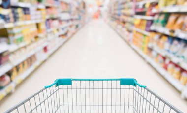 Soyut bulanık süpermarket indirim mağazası koridoru ve ürün rafları olan boş alışveriş arabası.