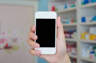 Eczanede el ele tutuşan akıllı telefon.