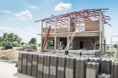 İnşaat alanında yeni ev inşa etmek için çatı kiremitleri yığını