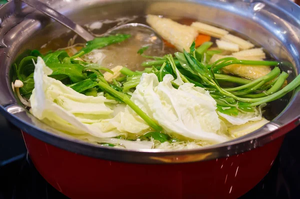 Sebzeler sukiyaki kabında kaynıyor.