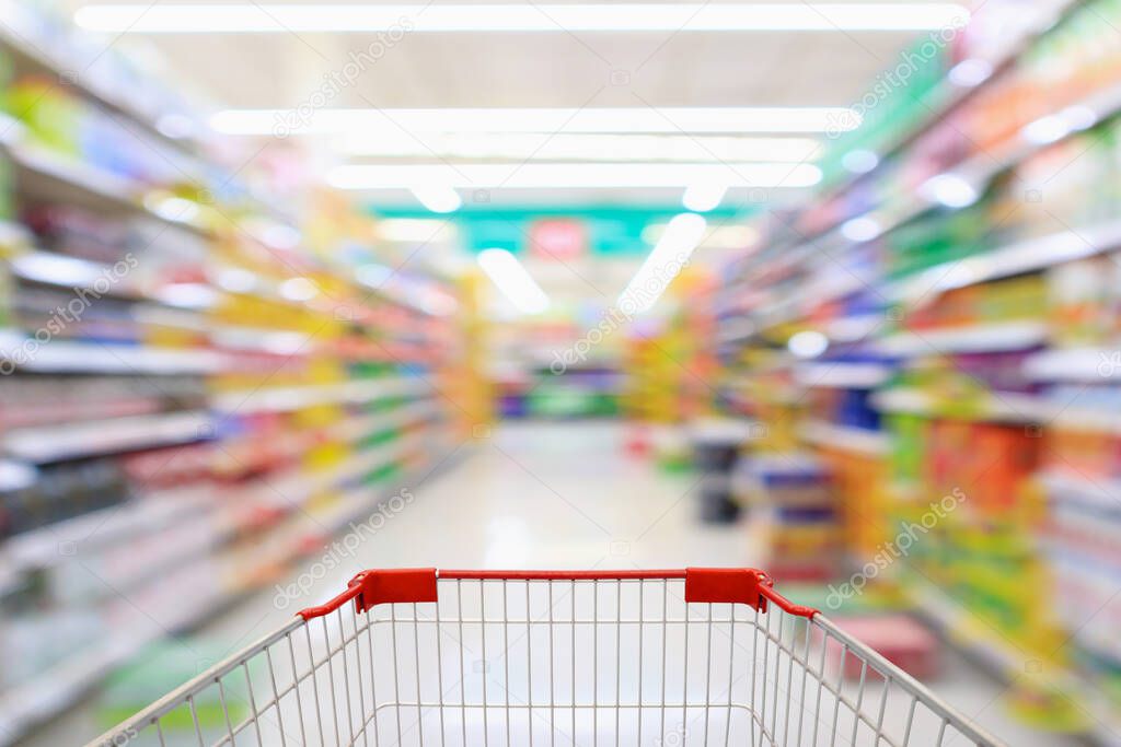 Shopping cart with supermarket aisle blur abstract background