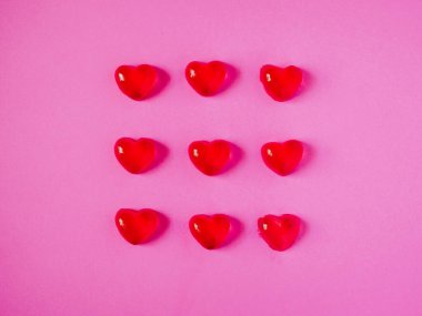 Pembe arka planda kırmızı sevgililer günü şekeri şekilleri