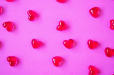 Sevgililer Günü geçmişi, pembe arka planda kalp şeklinde şekerler.