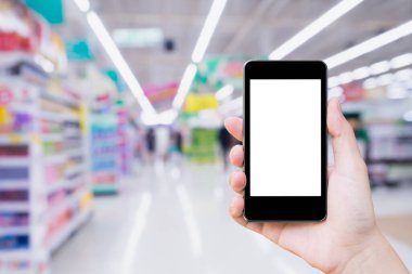 Markette alışveriş yaparken cep telefonu kullanan bir kadın