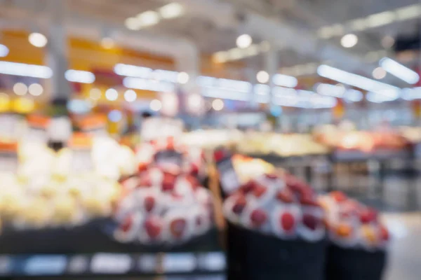 Grocery store with fresh fruits and vegetables shelves in supermarket blur defocused background