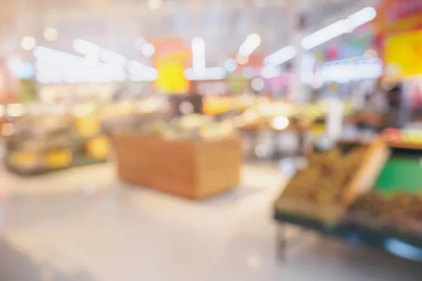 Supermarket with fresh fruits and vegetable on shelves in store blurred grocery background