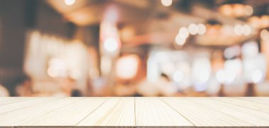 Ahşap masa üstü restoran kafesi ya da kafenin içi soyut odaklanmış bulanık arka planı olan insanlarla dolu.