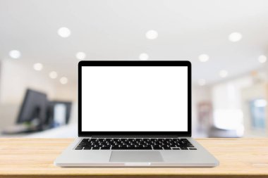 Ofis içi bulanık masadaki boş ekranlı dizüstü bilgisayar.