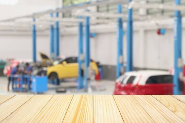 Araç servis merkezinin üzerinde boş ahşap masa ve tamir istasyonunda otomatik olarak bokeh ışığı odaklanmış bulanık arkaplan