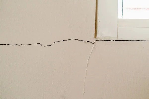 窓枠の近くの新しい家の壁の亀裂 — ストック写真