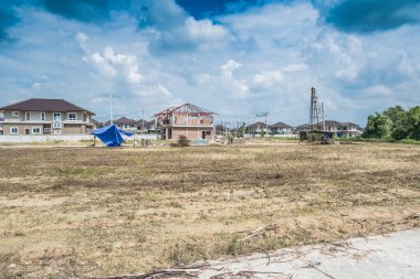 İnşaat alanında bulutlu ve mavi gökyüzü olan yeni bir ev.