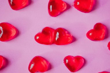 Sevgililer Günü geçmişi, pembe arka planda kalp şeklinde şekerler.