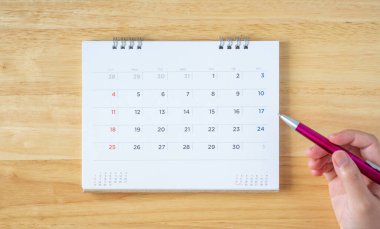 Takvim sayfası masa üzerinde kadın eli kalem, üst görünüm