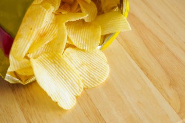 Tahta masada patates cipsi açık.