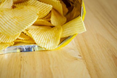 Tahta masada patates cipsi açık.