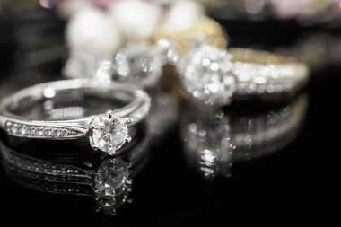 Siyah arka planda yansıması olan lüks mücevher yüzükleri.