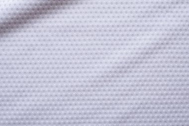 Beyaz kumaşlı spor giyimli futbol forması, hava ağı desenli.