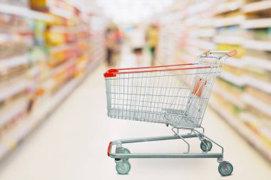 Süpermarket koridoru boş kırmızı alışveriş arabasıyla bulanık arka plan