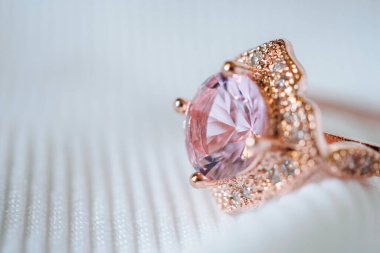 Mücevherler, beyaz kumaş arka planda pembe altın safir elmas yüzük.