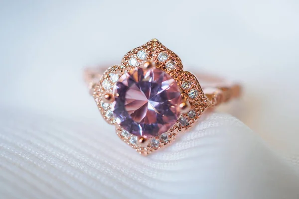 Jewelry luxury pink gold sapphire gemstone ring on white fabric background