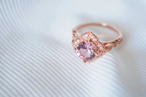 Jewelry luxury pink gold sapphire gemstone ring on white fabric background