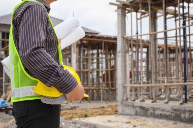 Asyalı işadamı inşaat mühendisi. İnşaat alanında koruyucu miğferi var.