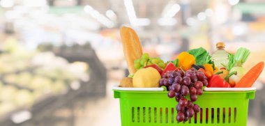 Meyve ve sebzelerle dolu alışveriş sepeti süpermarket marketi ile bulanıklaştırılmış arka plan bokeh ışığı ile bulanıklaştırılmış