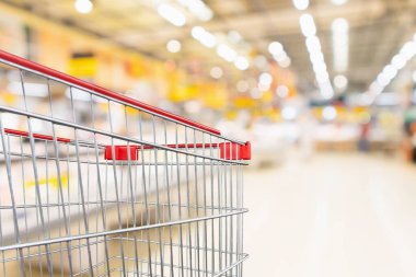 Boş kırmızı alışveriş arabası, soyut süpermarket indirimli mağaza koridoru ve ürün rafları, iç mekan, odaklanmış arka plan.