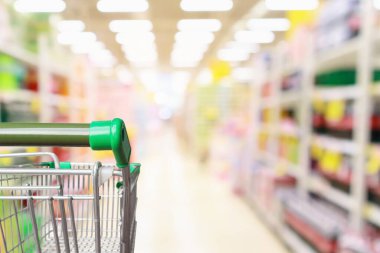 Boş yeşil süpermarket alışveriş arabası soyut bulanık market koridoru odaklanmış arka plan