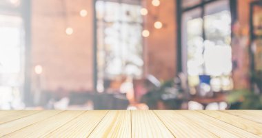Boş ahşap masa üstü, restoran kafesi ya da müşteri bulanıklığı olan kahve dükkânı içi montaj ürün görüntüleme arka planı için soyut vintage stil bokeh ışığı